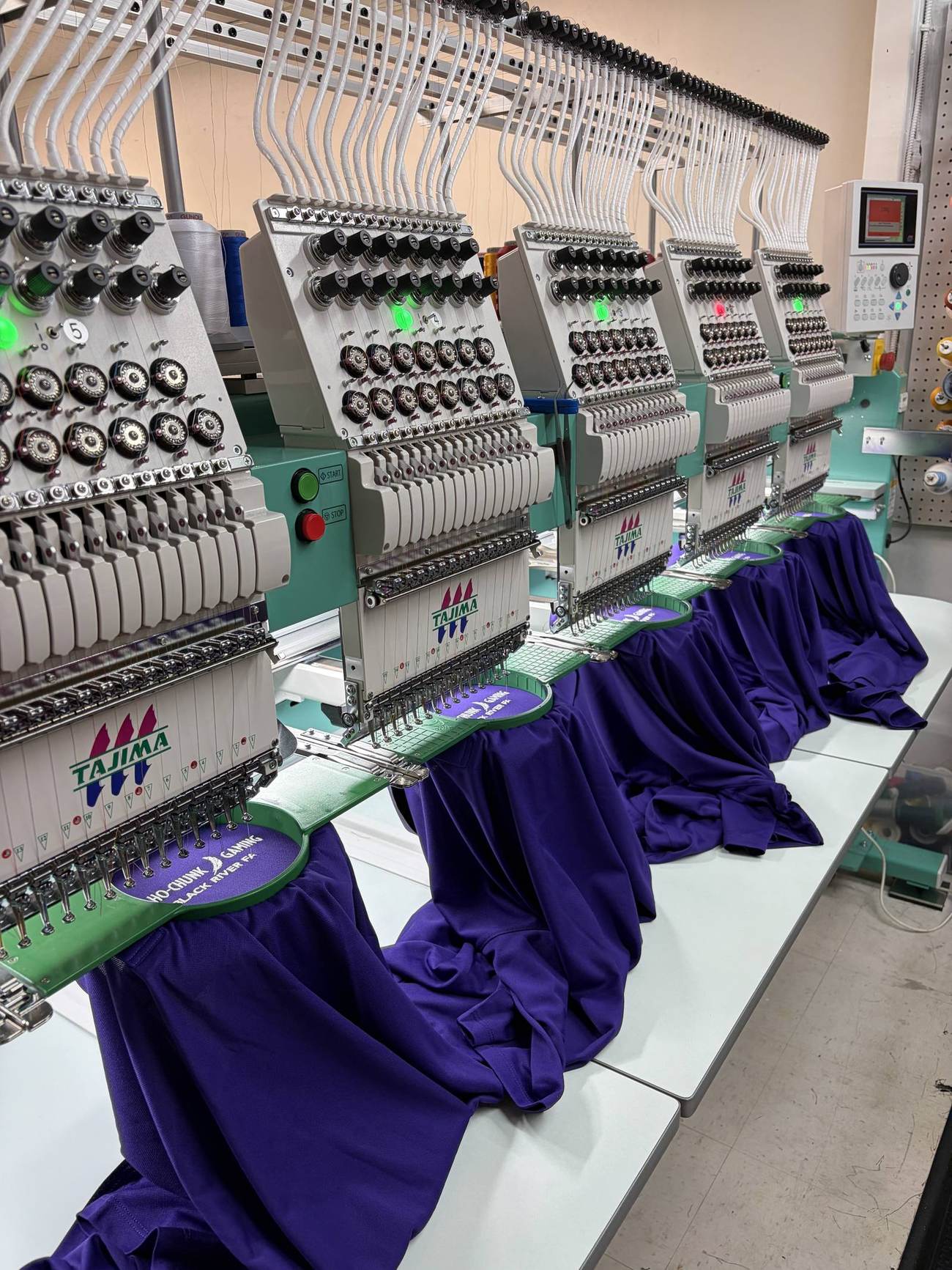 Multi-head embroidery machines running a production order at WeAddALogo